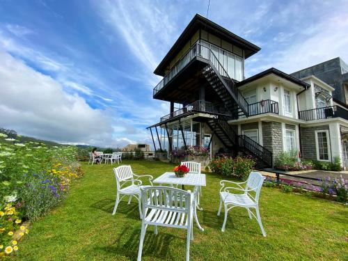 a table and chairs in front of a house at Friendly Hills Hotel in Nuwara Eliya