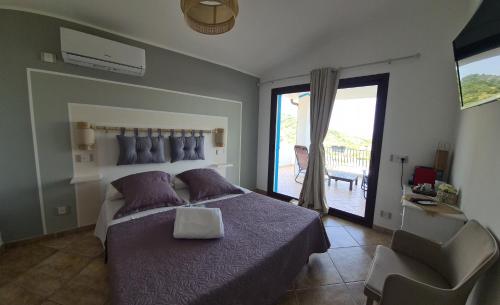 sypialnia z łóżkiem i przesuwanymi drzwiami szklanymi w obiekcie B&B Tiscali w mieście Dorgali