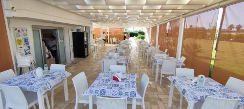 a row of tables and chairs in a restaurant at Samanà Bed and Breakfast in Punta Prosciutto