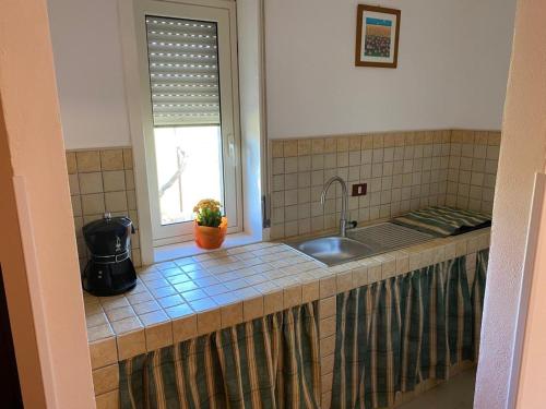 un bancone della cucina con lavandino e finestra di Casa vacanze Sicilia a Casteltermini