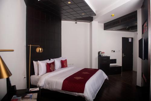 a bedroom with a large bed with red pillows at Ramada by Wyndham Gangtok Hotel & Casino Golden in Gangtok