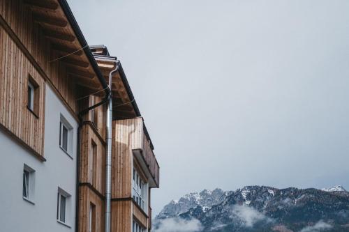 a view of the mountains from between two buildings at Apart33 by Apart4you in Haus im Ennstal