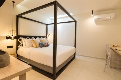 a bedroom with a white bed with a black frame at C Suites in Rethymno Town