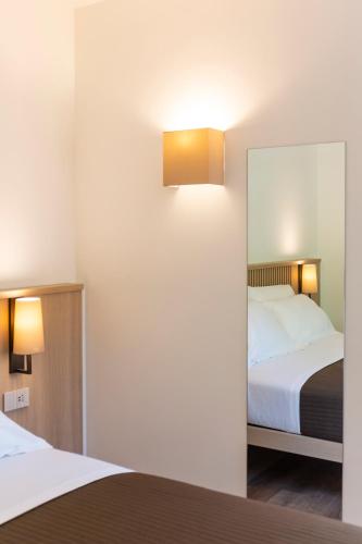 a bedroom with two beds and a mirror at Le Stanze del Lago Villa Seta in Como