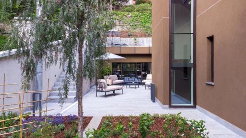 a courtyard of a building with chairs and a tree at Le Stanze del Lago Villa Seta in Como