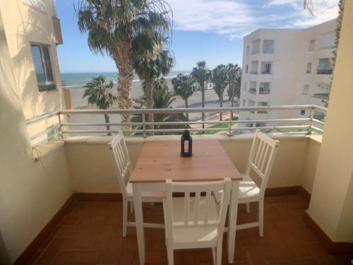 a table and chairs on a balcony with a view of the ocean at Motril - Poniente Beach in Motril