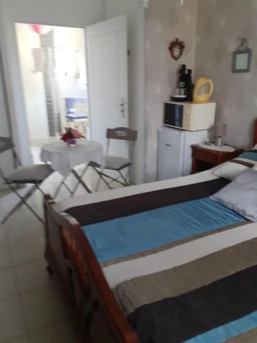 a bedroom with a bed and chairs in a room at La salamandre, Chambre d'hôtes in Étaules
