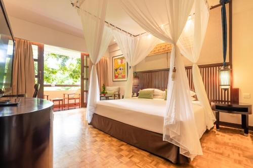 بينتانغ بالي ريزورت في كوتا: غرفة نوم بسرير مع مظلة