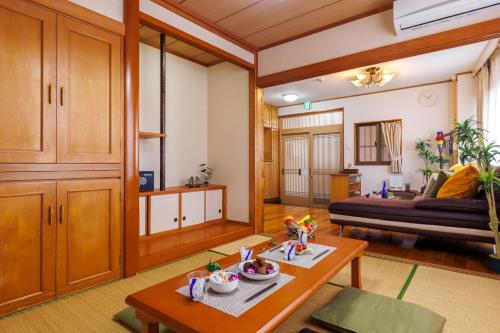 a living room with a table and a couch at Naha Gajumaru Apartment Hotel 301 in Naha
