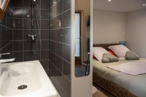 ein Badezimmer mit einem Waschbecken und ein Schlafzimmer mit einem Bett in der Unterkunft Chambre Folle Avoine in Brié-et-Angonnes