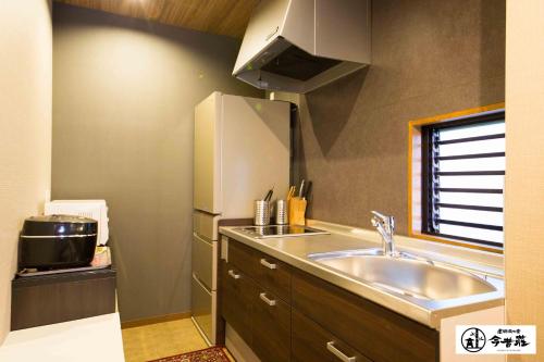 a kitchen with a sink and a refrigerator at Konjaku-So Dotonbori Penthouse Stay in Osaka