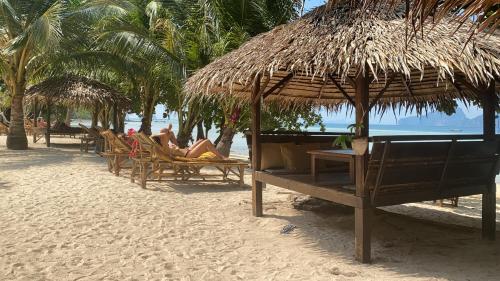a group of people sitting in chairs on a beach at KALUME' Eco Boutique Resort-Adult only in Koh Kradan