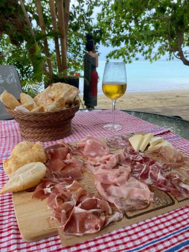 a cutting board with meat and bread and a glass of wine at KALUME' Eco Boutique Resort-Adult only in Koh Kradan