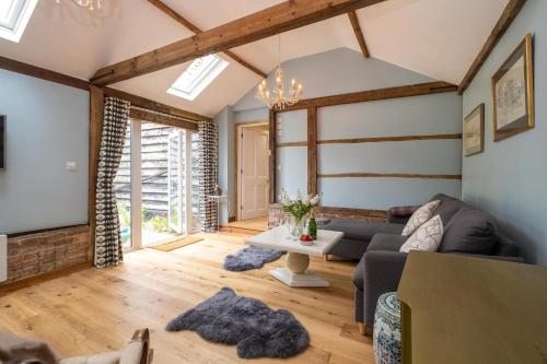 a living room with a couch and a table at The Cart Lodge - Aldeburgh Coastal Cottages in Wickham Market