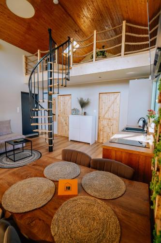 a room with a table and a spiral staircase at Szumiące Trawy - Bory Tucholskie in Tleń