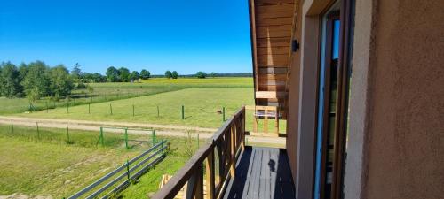 a balcony of a house with a view of a field at Zakątek Ciszy. in Słuchowo