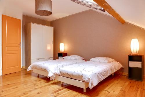 - une chambre avec deux lits et deux lumières sur le mur dans l'établissement Isida, Maison spacieuse avec terrasse et stationnement, à Caen