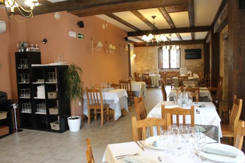 een restaurant met witte tafels en stoelen en een eetkamer bij Hotel Rural Restaurante Las Baronas in Santa Cruz de la Salceda