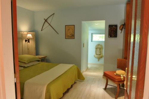 um quarto com uma cama, uma mesa e uma cadeira em Le Pavillon du Lac em La Brede