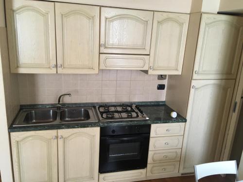 a kitchen with white cabinets and a stove top oven at I 3 FRATELLI in Foligno