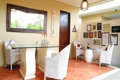 a dining room with a glass table and chairs at Villa with private pool at Villa Nirvana Ubud in Ubud