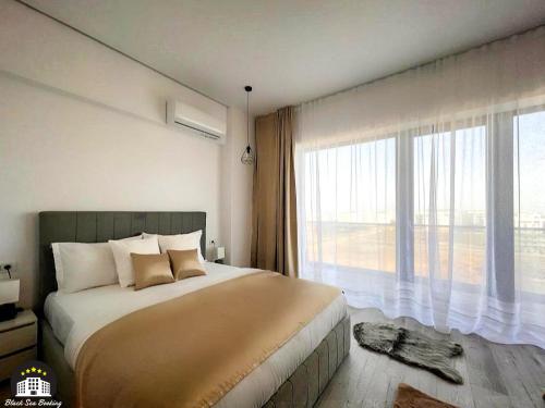 - une chambre avec un grand lit et une grande fenêtre dans l'établissement Black Sea Booking-London, à Mamaia Nord – Năvodari