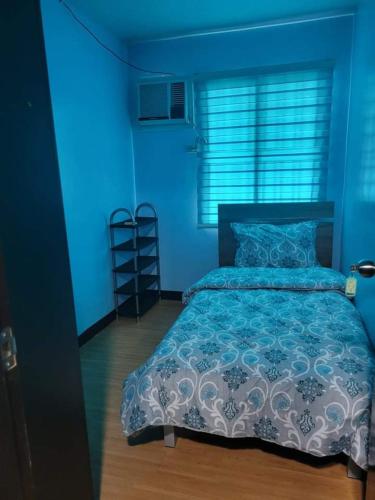 una camera blu con un letto in sfondo blu di Tisa labangon condo a Labangon