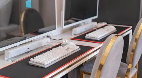 a desk with two computer monitors and a keyboard at Denbasta forest Hotel in Busan