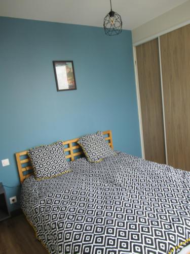 - une chambre dotée d'un lit avec un mur bleu dans l'établissement Forges 5, à Saujon