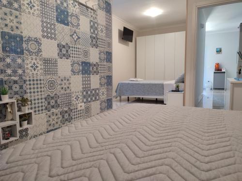 um quarto com uma cama grande e uma parede em azulejo em Midway House Italy em Sant'Egidio del Monte Albino