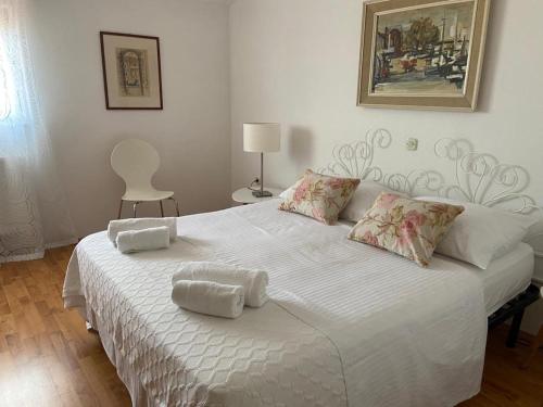 a white bed with two towels on top of it at Apartment in Maslinica 70m from the sea in Maslinica