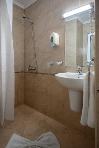 a bathroom with a sink and a shower with a mirror at Къща за гости Екстаси in Primorsko