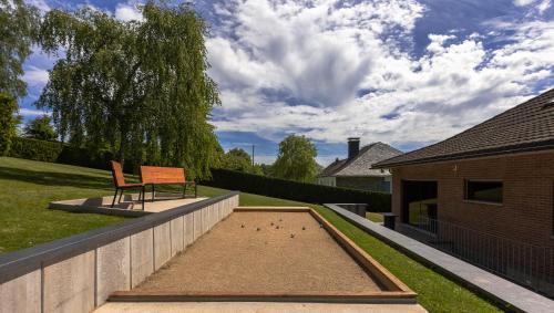 un banc assis sur un mur dans une cour dans l'établissement Luxueuse et spacieuse villa avec sauna et piscine, à Malmedy