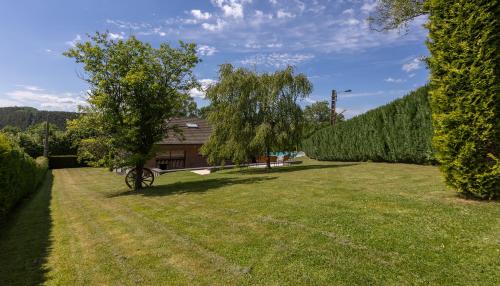 a large yard with a house and a tree at Luxueuse et spacieuse villa avec sauna et piscine in Malmedy