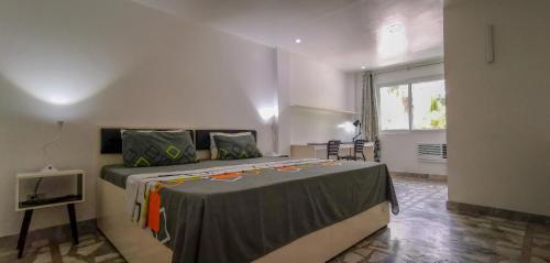 a bedroom with a bed with a table and a window at The Three P Beach Resort & Dive Center in Romblon