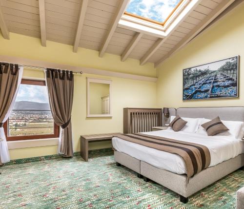 a bedroom with a large bed and a window at Castrum Wine Relais in San Pietro in Cariano
