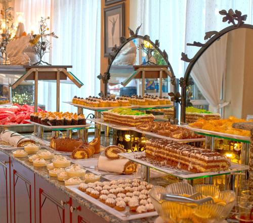 una linea a buffet con molti tipi di dolci di Hotel Sinatra - All Inclusive a Kemer