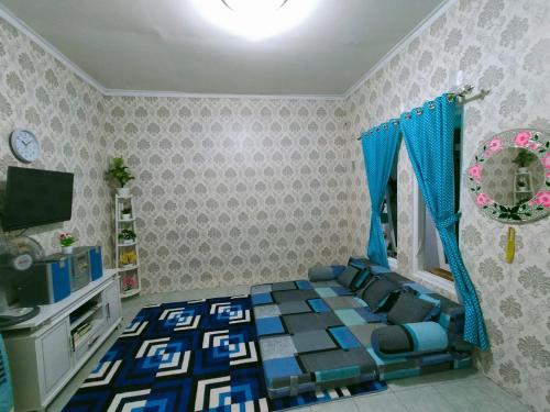 a bedroom with a bed and a tv in it at Shifana homestay syariah in Yogyakarta