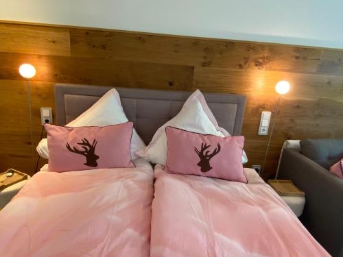 - une chambre avec 2 lits et des oreillers roses dans l'établissement Studio Lofer, à Sankt Martin bei Lofer