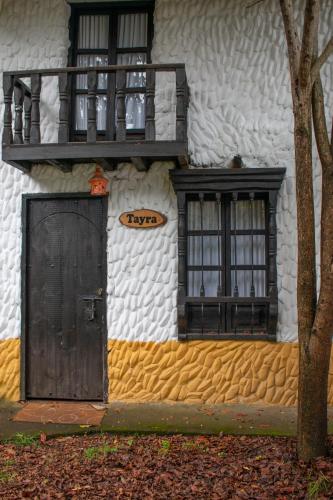 a building with a door and windows and a balcony at Hotel Museo la Posada del Molino in El Cocuy