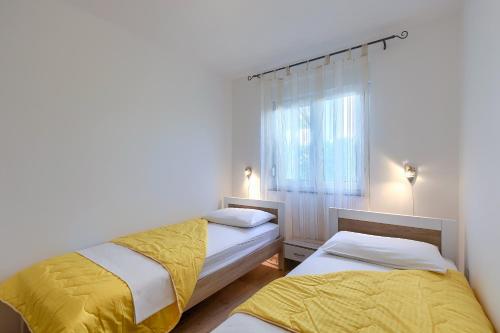 a bedroom with two beds and a window at Apartments Gilly 2 in Premantura