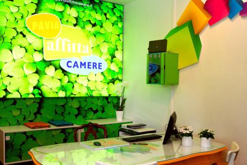 a conference room with a green wall with a sign at Affittacamere Pavia in Pavia