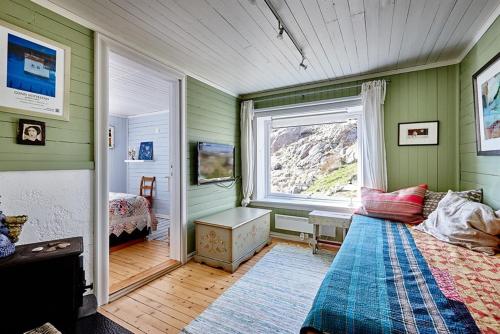 a bedroom with green walls and a bed and a window at Nyksund House Kapellbakken 3 bedrooms with sea view in Nyksund