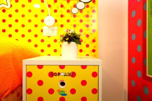 a room with a yellow and red polka dot wall at Affittacamere Pavia in Pavia