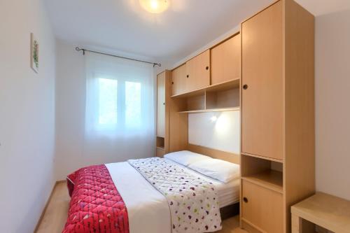 a small bedroom with a bed and a closet at Apartments Gilly 2 in Premantura