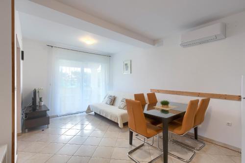 a living room with a table and a couch at Apartments Gilly 2 in Premantura