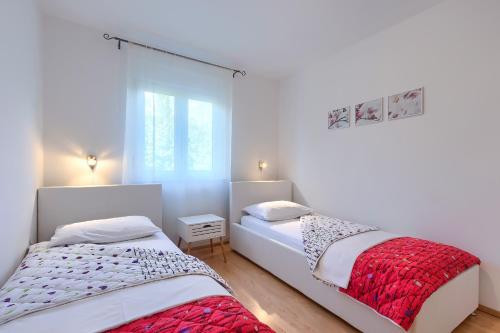 two beds in a room with white walls at Apartments Gilly 2 in Premantura