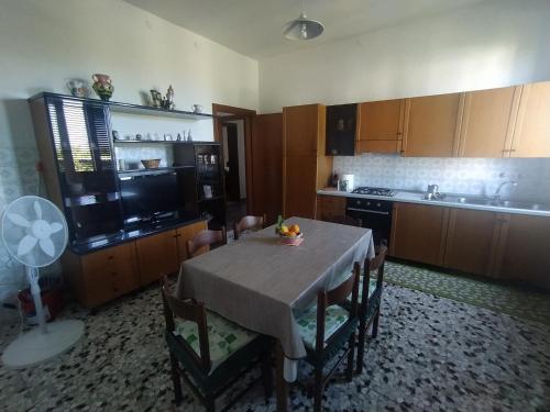 a kitchen with a table and chairs and a kitchen with a fan at Casa Duilia: una villa tra mare e collina in San Vito Chietino