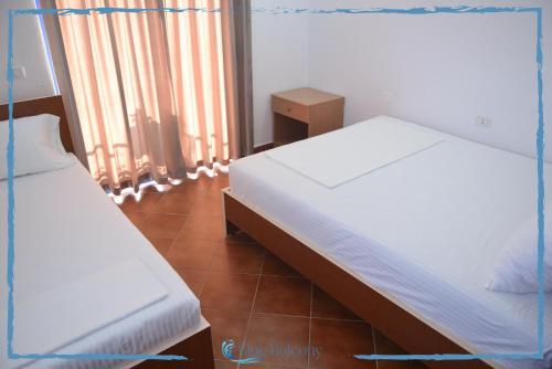 a bedroom with two beds and a window at Blue Balcony Hotel in Golem