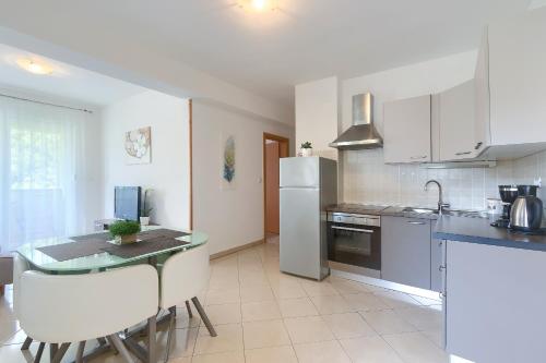 a kitchen with a table and a white refrigerator at Apartments Gilly 2 in Premantura
